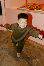 Child having fun in Downtown Set Pistachio Truffle kids tracksuit while having a cookie